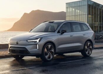 Rear three-quarter view of a light blue Volvo EX60 concept SUV with distinctive taillights, set against a screen announcing the global reveal on January 21, 2026.